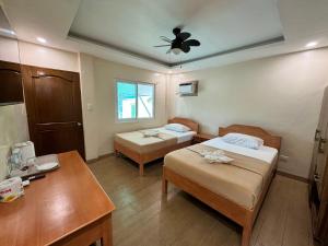 una camera d'albergo con due letti e un tavolo di Marina Village a Moalboal
