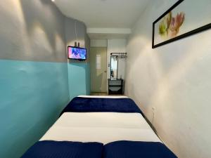 a bedroom with a bed and a tv on the wall at Suites Brisa Marina - Playa Regatas y Malecón in Veracruz
