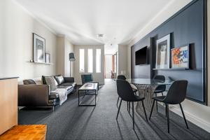 un soggiorno con divano, tavolo e sedie di Style and Convenience on Little Bourke a Melbourne