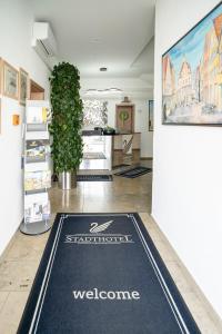 alfombra de bienvenida en el suelo de una habitación en Stadthotel Giengen en Giengen an der Brenz