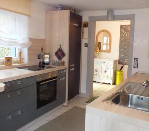 een keuken met een spoelbak en een fornuis bovenste oven bij Ferienhaus Landau in Landau an der Isar