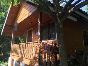 a man standing on the front porch of a house at Sin U Rai Resort in Ko Larn