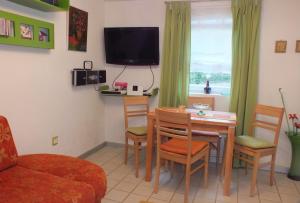 ein Wohnzimmer mit einem Tisch, Stühlen und einem TV in der Unterkunft Ferienhaus Landau in Landau an der Isar