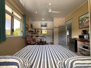 um quarto com 2 camas e uma cozinha com uma janela em Meri Lodge Huahine « ROOM OF MARTA » em Fare