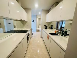 a large white kitchen with white cabinets and counters at Vortex Suites KLCC by Nadia Guesthouse Kuala Lumpur in Kuala Lumpur