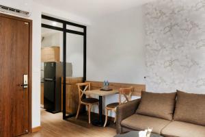 a living room with a couch and a table and a refrigerator at Studio apartment in Hoan Kiem in Hanoi