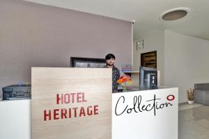 a man standing behind a hotel heritage sign at Collection O Hotel Heritage in Indore