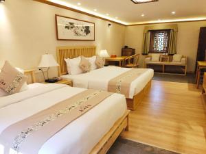 pokój hotelowy z 2 łóżkami i salonem w obiekcie Yangshuo Ancient Garden Boutique Hotel w mieście Yangshuo