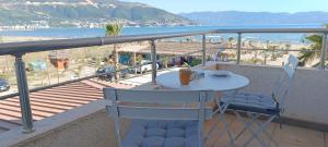 un tavolo e sedie su un balcone con vista sulla spiaggia di Eirik's beachfront apartments & penthouse a Vlorë