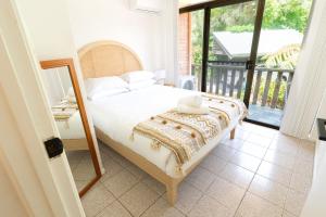 a bedroom with a bed and a balcony at Surfers Rest in Byron Bay