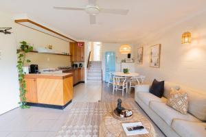 a living room with a couch and a kitchen at Surfers Rest in Byron Bay