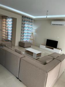 a living room with a couch and a table at 4Bedroom villa in pharos in Mountain view 98 B in Zāwiyat al ‘Awwāmah