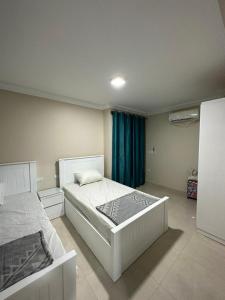 a bedroom with a white bed and a blue curtain at 4Bedroom villa in pharos in Mountain view 98 B in Zāwiyat al ‘Awwāmah