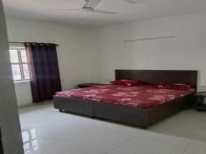 een slaapkamer met een bed met een rood dekbed bij SPOT ON Hotel Deepak Palace in Amritsar