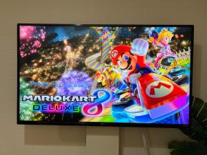 a television screen with a mario kart movie on it at 渋谷Eアドレス in Tokyo