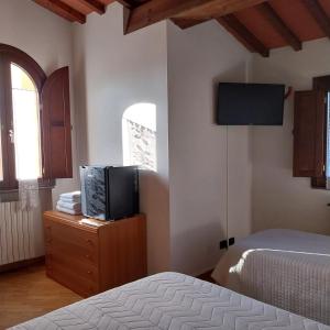 a bedroom with a bed and a television on a dresser at Bed&Breakfast Pianeta Benessere in Pistoia