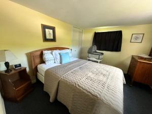a hotel room with a bed and a window at Cozy Riverfront Cottage with dock close to Lake George in Corinth