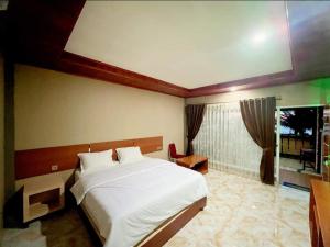 sypialnia z dużym białym łóżkiem i oknem w obiekcie Jelita Beach Mentawai w mieście Tua Pejat
