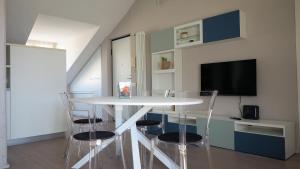a dining room with a white table and chairs at Blu Note Apartment in Turin +21 photos