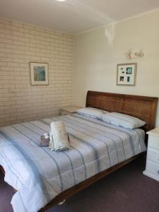 Un dormitorio con una cama con un animal de peluche encima. en Kalbarri Reef Villa 2, en Kalbarri 10 fotos más