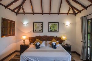 a bedroom with a bed with two penguins on it at Hotel Chateau St Cloud in La Digue