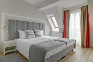 a bedroom with a large bed and a window at Hotel & Spa Trzy Wyspy in Świnoujście