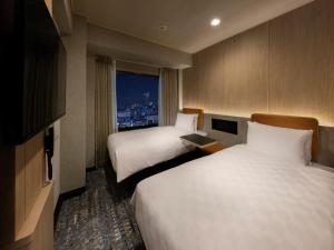 a hotel room with two beds and a window at Shinjuku Prince Hotel in Tokyo