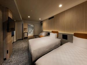 a hotel room with two beds and a television at Shinjuku Prince Hotel in Tokyo