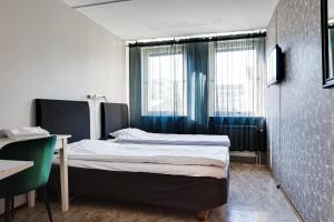 um pequeno quarto com uma cama e uma janela em Drottninggatans Vandrarhem em Karlskrona