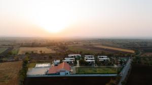 an aerial view of a house with the sunset in the background at Daksh Eden Greenz -A Luxury Resort in Sasan Gir in Sasan Gir