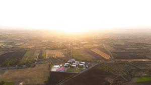 an aerial view of a field with houses and trees at Daksh Eden Greenz -A Luxury Resort in Sasan Gir in Sasan Gir