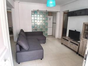 een woonkamer met een bank en een tv bij Nuestra Casa en Gran Alacant in Gran Alacant
