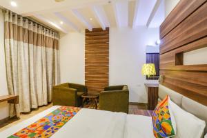 FabHotel Prime Mahendra في رايبور: غرفة بسرير ومكتب وكراسي