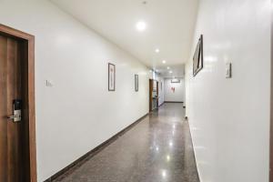 un pasillo vacío con paredes blancas y una puerta en FabHotel Prime Mahendra, en Raipur