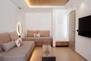 a living room with a couch and a television at Hotel Naxos Beach in Naxos Chora