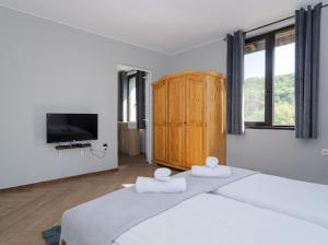 1 Schlafzimmer mit 2 Betten und einem Flachbild-TV in der Unterkunft Къща "Конакъ" in Kjustendil