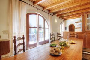 comedor con mesa de madera y ventana grande en Askoutsi Manor, a Natural Tranquil Retreat, By ThinkVilla, en Áyios Ioánnis