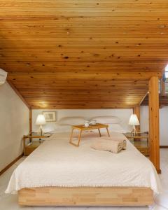 um quarto com uma cama grande e um tecto em madeira em Villa Sevasti Vintage Loft, Panel Hospitality Homes & Villas em Platamon