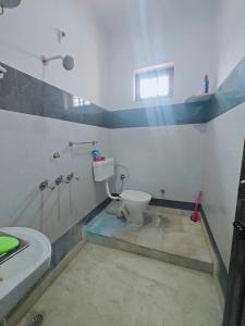 a bathroom with a toilet and a shower and a sink at Lata Home Stay in Haridwār