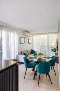 ein Wohnzimmer mit einem Tisch, Stühlen und einem Sofa in der Unterkunft VAQUAY Valentino In Southbank in Melbourne