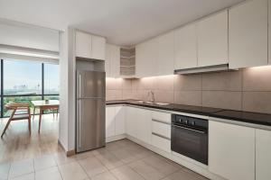 a kitchen with white cabinets and stainless steel appliances at Sheraton Hanoi West in Hanoi