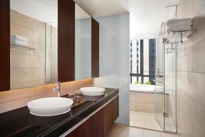 a bathroom with two sinks and a mirror at Sheraton Hanoi West in Hanoi
