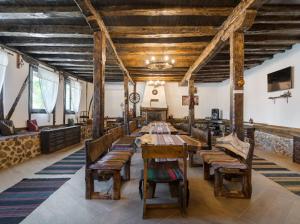 pokój z drewnianymi stołami i ławkami w budynku w obiekcie Къща "Конакъ" w mieście Kiustendił
