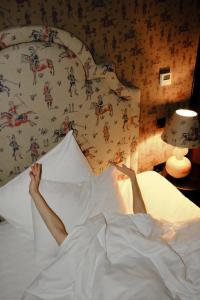 a person laying in bed with their feet on a pillow at Communal Hotel Kutaisi in Kutaisi