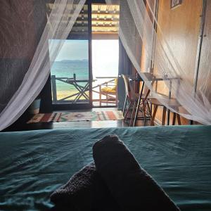 a bedroom with a bed and a view of the ocean at The Station Tioman in Tioman Island