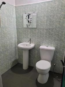 a bathroom with a toilet and a sink at The Station Tioman in Tioman Island