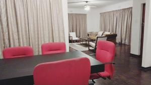 a conference room with a table and red chairs at Cozy Retreat Ferndale in Johannesburg +26 photos