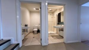 a bathroom with a toilet and two sinks and a shower at K2 - Thirteen in Mount Buller +18 photos
