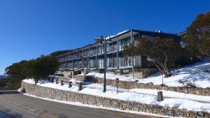 a building on the side of a snow covered street at K2 - Thirteen in Mount Buller