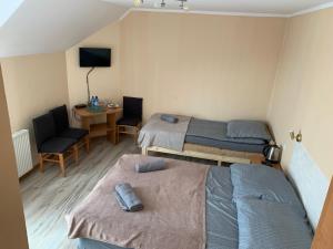 スバジェボにあるKaszub Swarzewo - Bed & Breakfastのベッド2台、デスク、椅子が備わる客室です。